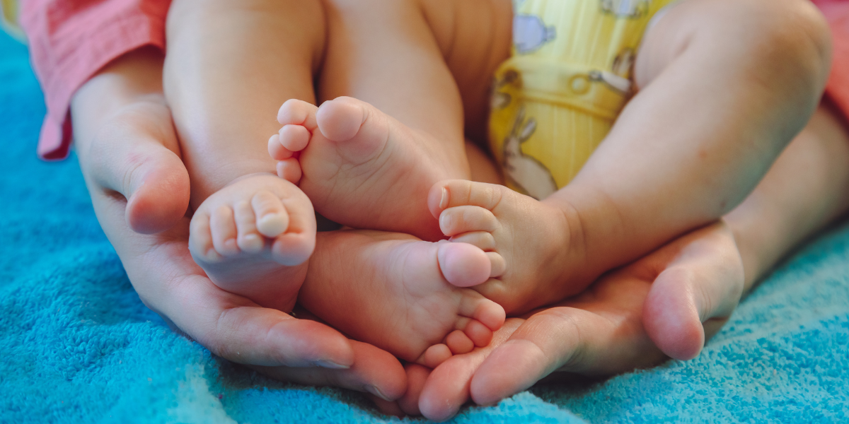 Stopy dziecka w dłoniach rodziców – troska o zdrowy rozwój (zdjęcie)