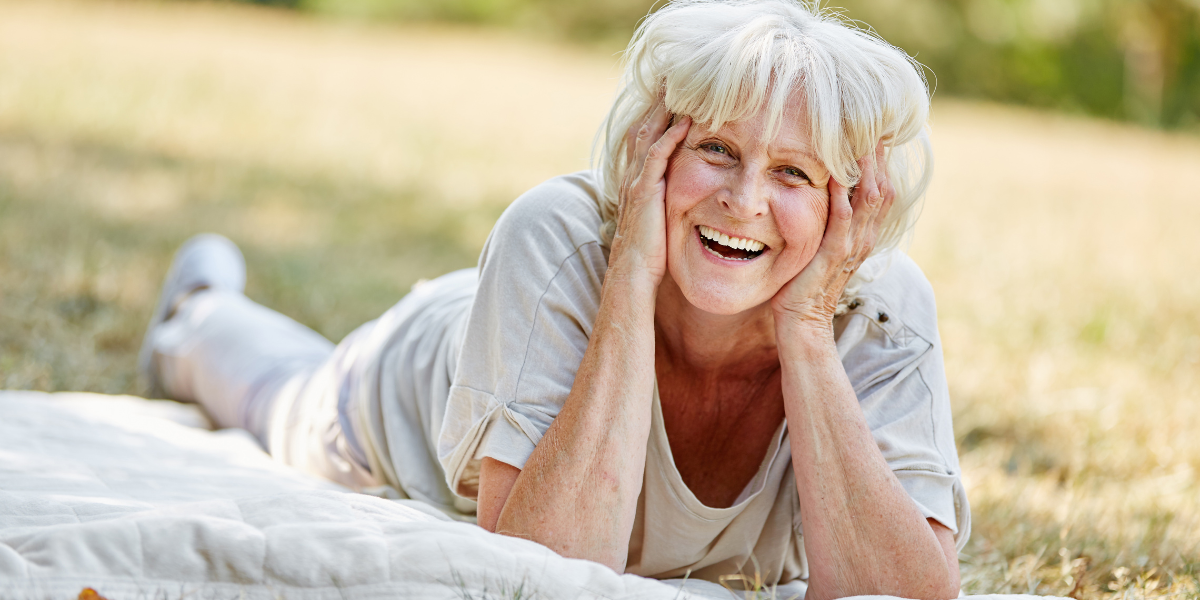 Szczęśliwa seniorka odpoczywająca w parku w wygodnych butach dla seniorów