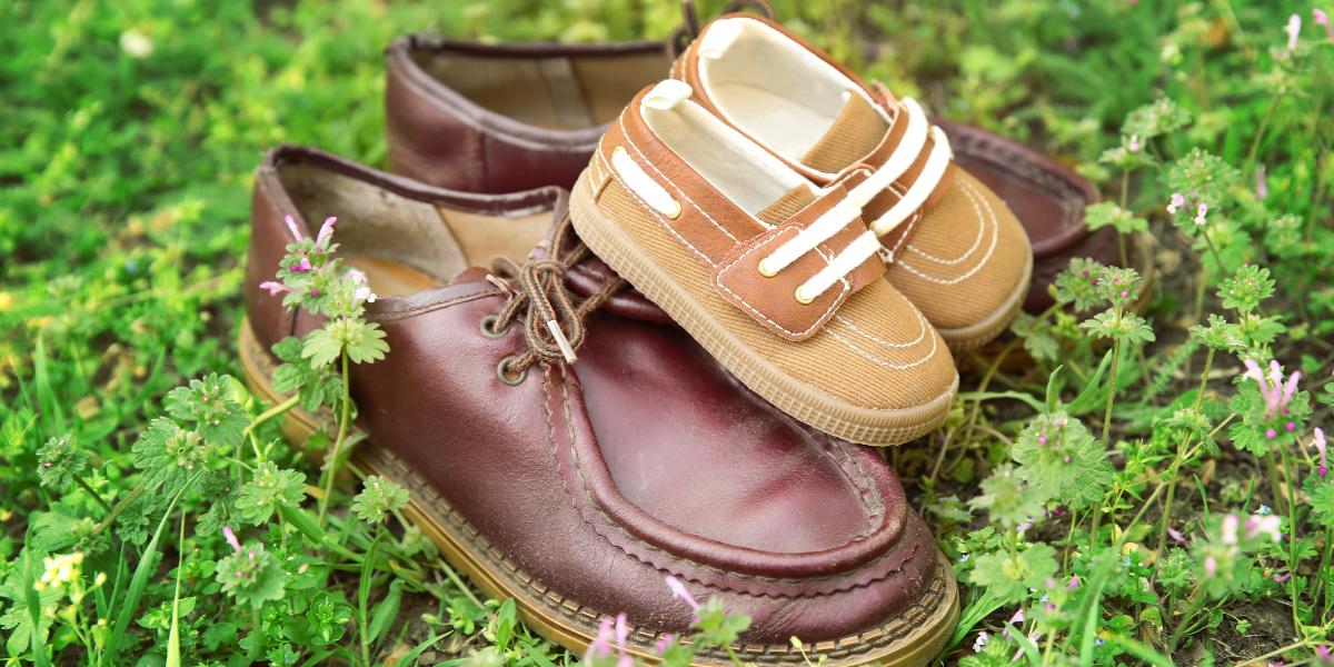 Male dziecięce buciki leżące na dużych męskich butach