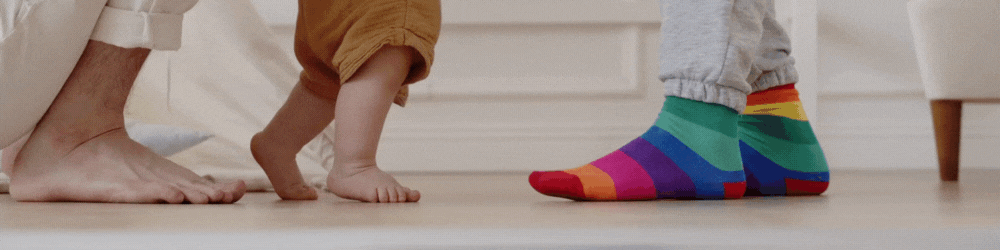 Dziecko stawiające pierwsze kroczki, idące w asyście rodziców